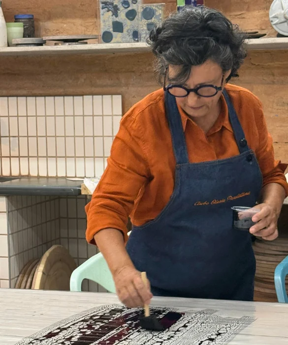 Lúcia Eid pintando um tecido de seda com pincel