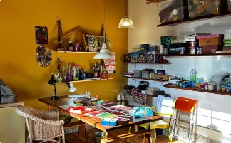 Interior do ateliê com parede amarela e materiais de arte organizados